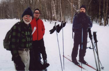 three men prepare to ski