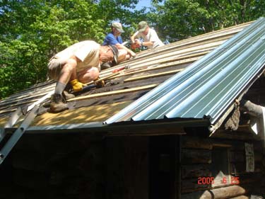 men hammering on roof